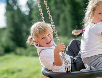 Lachende Kinder beim Schaukeln 